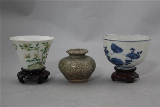 Two Chinese porcelain cups and a small crackle glaze vase, 17th - 19th century, 4.8cm., with wood stand